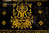 Wat Xieng Thong temple in Luang Prabang, Laos. Detail of the  intricate gold stencilling on black lacquer that decorate the walls of the sim.